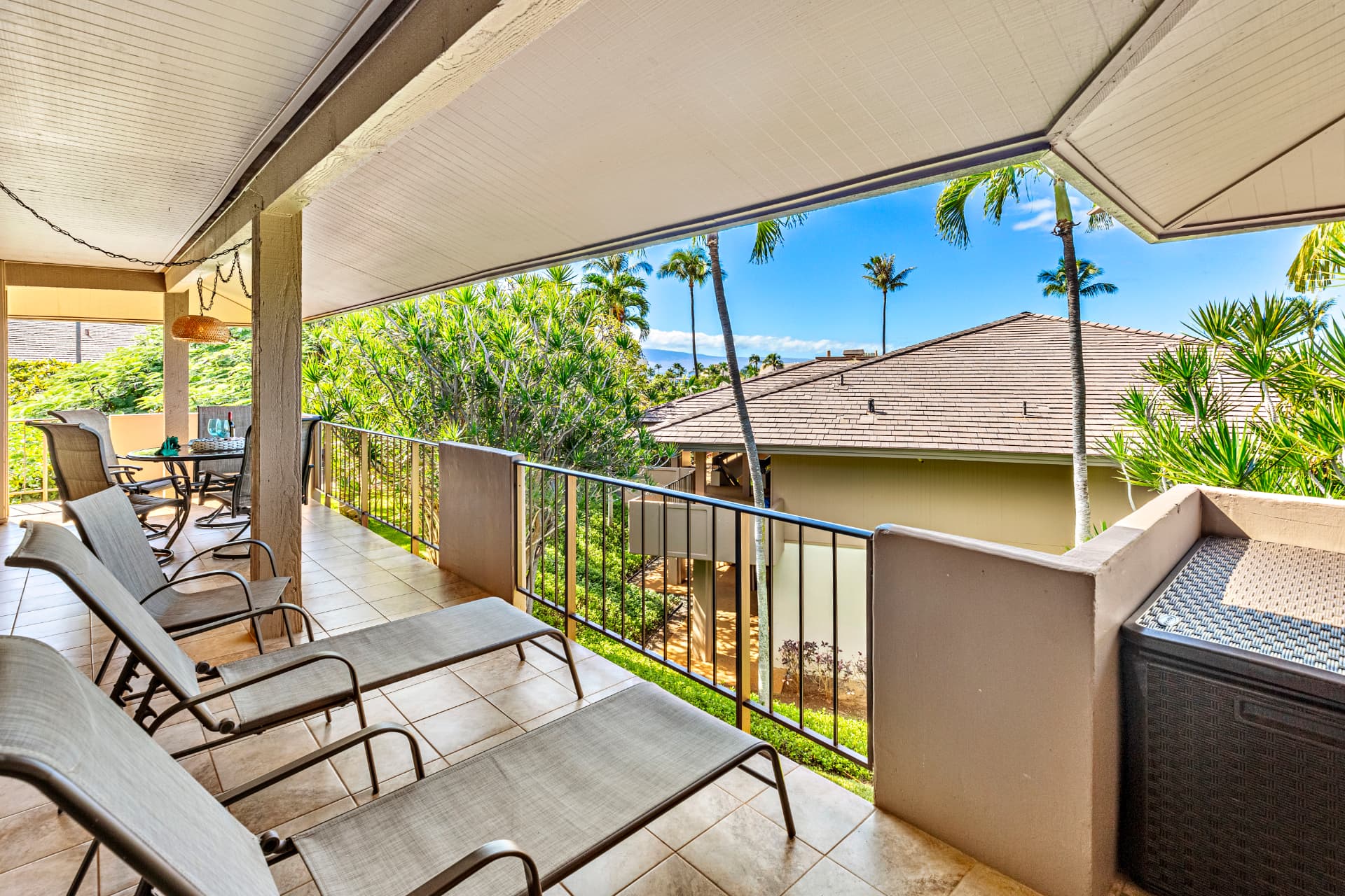 Suite F-201 private lanai with lounge chairs and tropical views